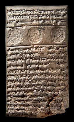 Clay tablet with inscribed cuneiform text, with a circular seal stamped three times into the surface